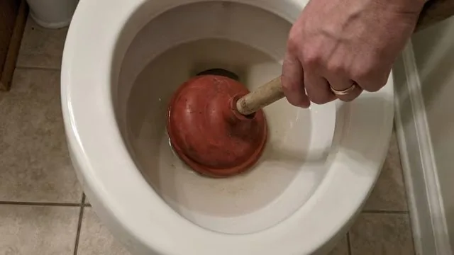 Plumber completing scrubbing debris from floor drain