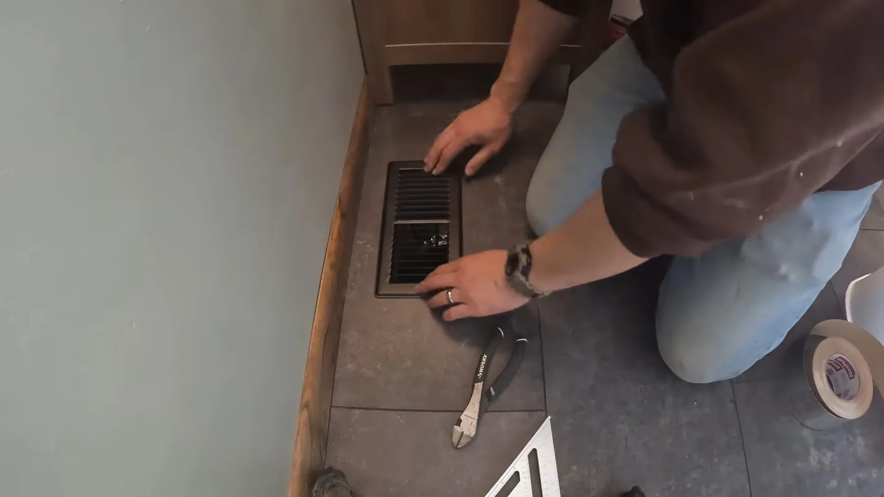 Tile installer working on bathroom floor at a Tempe residence